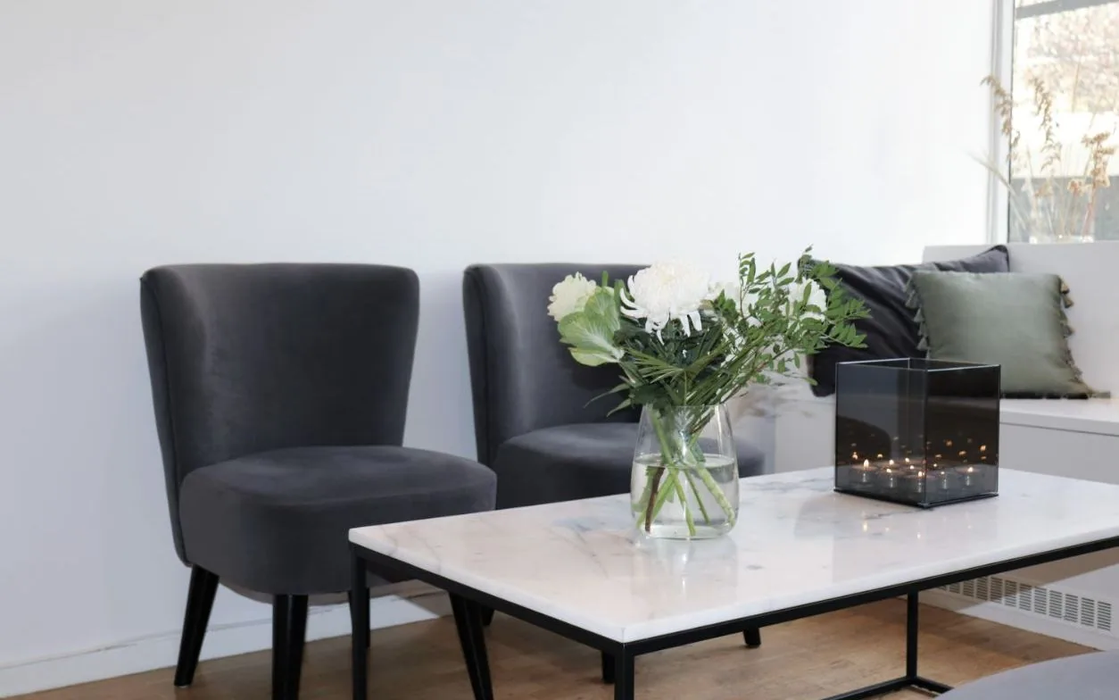 Väntrum med fåtöljer och marmorbord hos Caroli Skönhetslounge på Rundelsgatan i Malmö