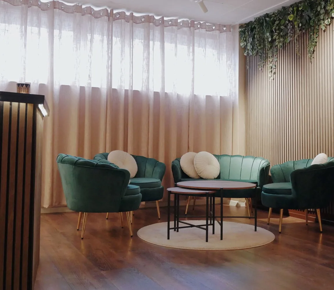 Väntrum med gröna sammetsfåtöljer hos Klinik 25 på Oxenstiernsgatan i Stockholm