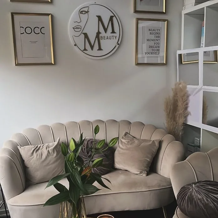 Väntrum med sammetssoffa och MM Beauty-logga hos MM Beauty Göteborg